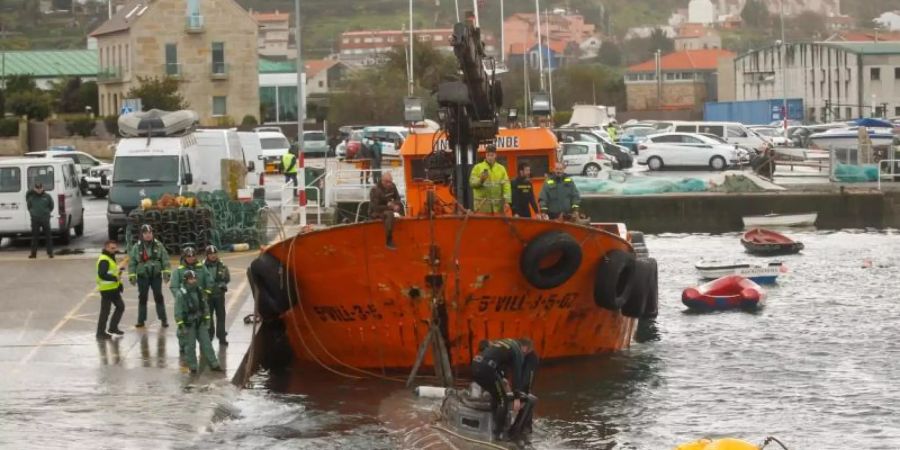 Ein Schlepper der Guardia Civil zieht ein gut 20 Meter langes Drogen-U-Boot aus dem Wasser, das vor der Küste der Region Galicien abgefangen worden war. Foto: Marta Vazquez Rodriguez/Europa Press/dpa