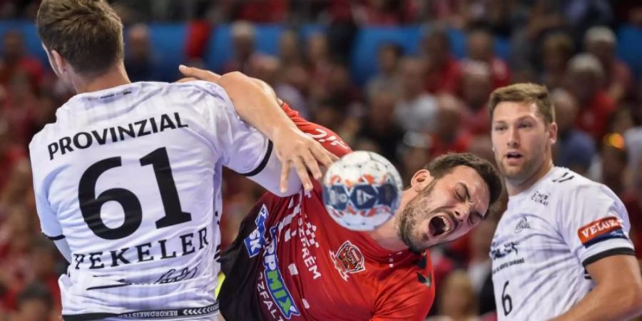 Veszprems Petar Nenadic (M) bleibt in der Abwehr von Hendrik Pekeler (l) und Harald Reinkind vom THW Kiel hängen. Foto: Boglarka Bodnar/MTI
