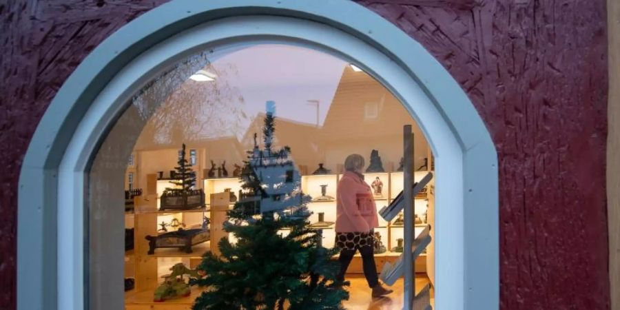 Durch ein Fenster im Christbaumständermuseum sind die Ausstellungsstücke zu sehen. Foto: Sebastian Gollnow/dpa