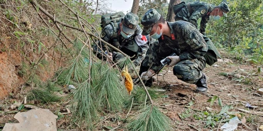 Einsatzkräfte untersuchen Trümmer der Maschine