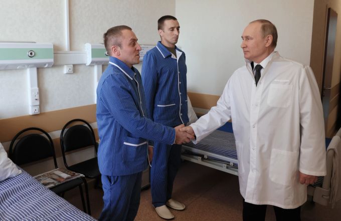 Der russische Präsident Wladimir Putin, rechts, schüttelt im Zentralen Militärkrankenhaus in Moskau, Russland, am Mittwoch, den 25. Mai 2022, die Hände des Offiziers Yuzbeg Kazitov, links, und des Feldwebels Ivan Petruk, zweiter von links. Kazitov und Petruk wurden während der russischen Militäroperation in der Ukraine verwundet. Russia Putin
