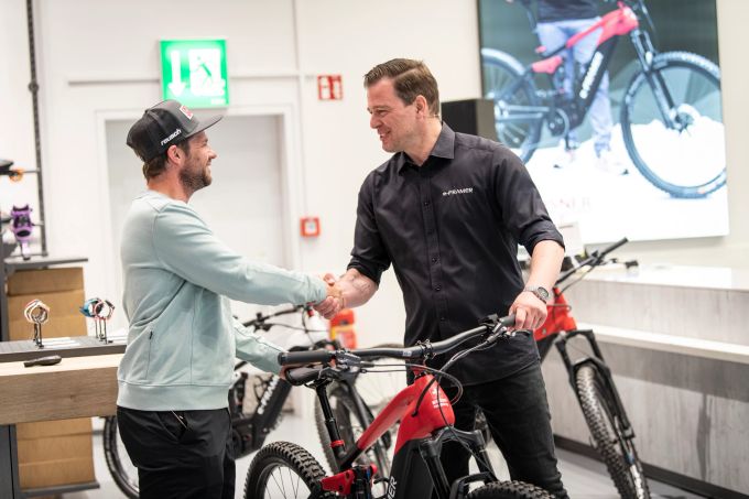 Auf ein gutes Gelingen. Beat Feuz und Adrian Schiess, Marketing-Leiter von e-FRAMER. E-Bikes Schweiz e-FRAMER Feuz