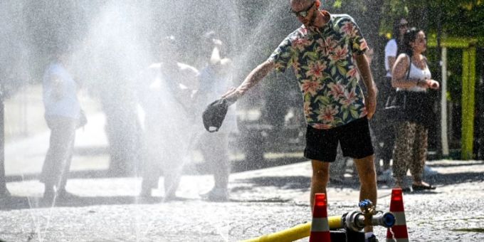 Menschen kühlen sich in Köln an einerm Sprühnebel Menschen kühlen sich in Köln an einerm Sprühnebel