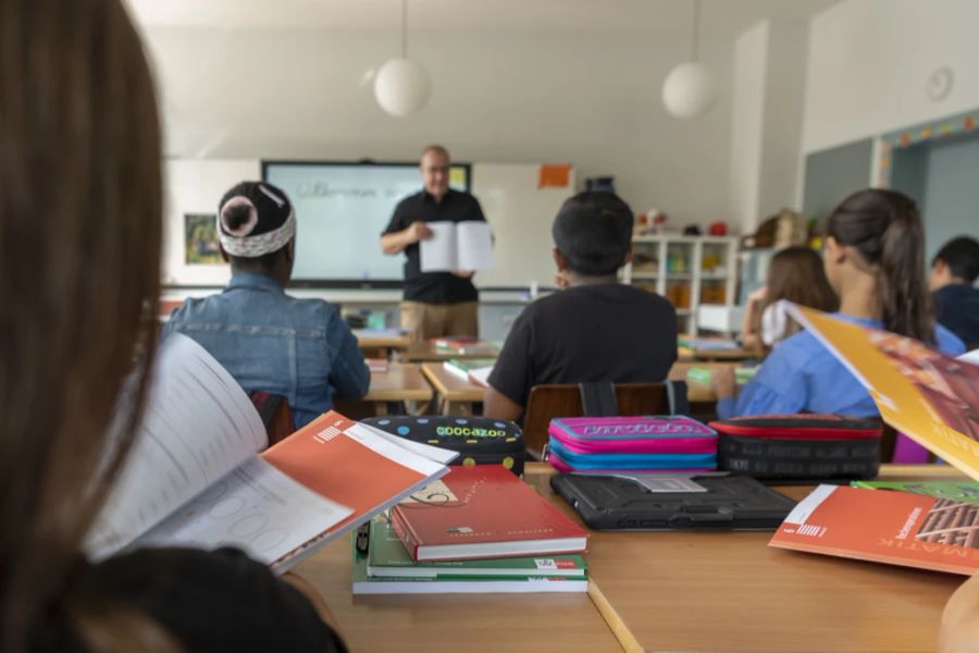 Die neuen Schulbücher werden einer Primarklasse vorgestellt.