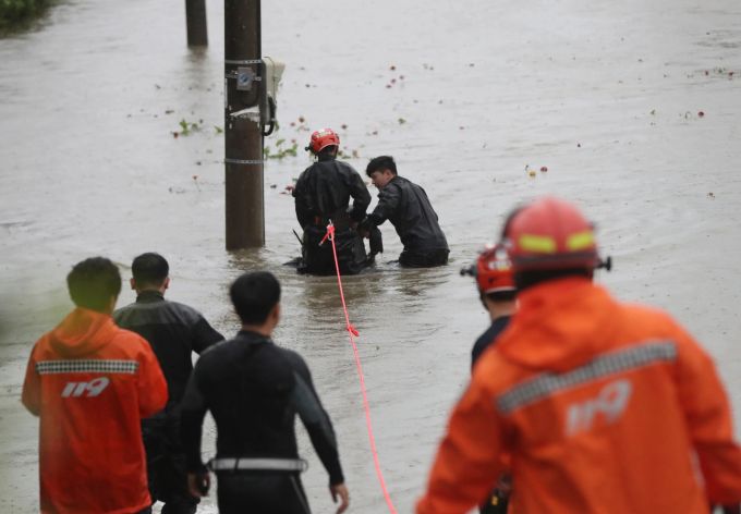 Südkoreanische Feuerwehrleute retten einen Bürger in der Nähe eines Flusses in Ulsan. Kim Yong-tai/Yonhap via AP/dpa Super-Taifun "Hinnamnor"