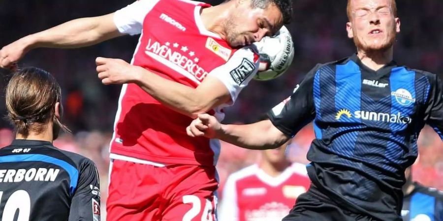 Union-Profi Manuel Schmiedebach (l) beim Kopfballduell mit Paderborns Sebastian Vasiliadis. Foto: Andreas Gora/dpa