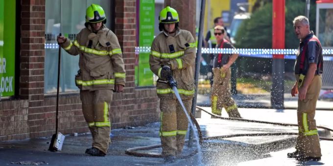 Feuerwehrleute reinigen den Tatort in Melbourne Feuerwehrleute reinigen den Tatort in Melbourne