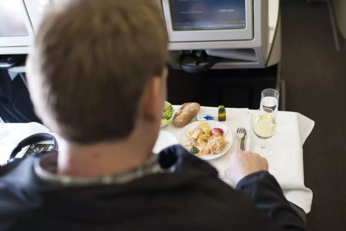 Ein Passagier beim Essen in der Business Class. businesss class