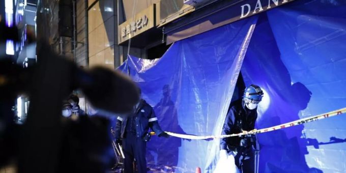 Polizisten ermitteln in dem abgesperrten Mehrfamilienhaus in Osaka, in dem es zu dem tödlichen Brand gekommen ist. Foto: --- osaka