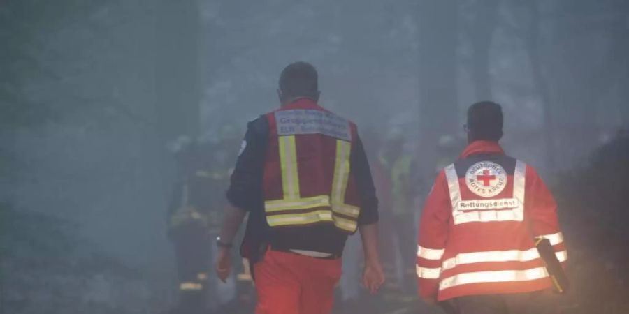 Einsatzkräfte in einem Wald bei Itterbach im Siebengebirge. Laut Polizei starben dort bei dem Absturz eines Kleinflugzeugs zwei Menschen. Foto: Thomas Banneyer/dpa
