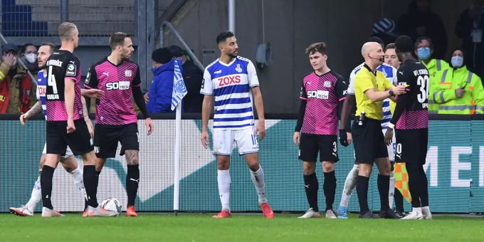 Aaron Opoku (re.) spricht mit Schiedsrichter Nicolas Winter nach rassistischen Beleidigungen von den Zuschauerrängen. MSV Duisburg VfL Osnabrück