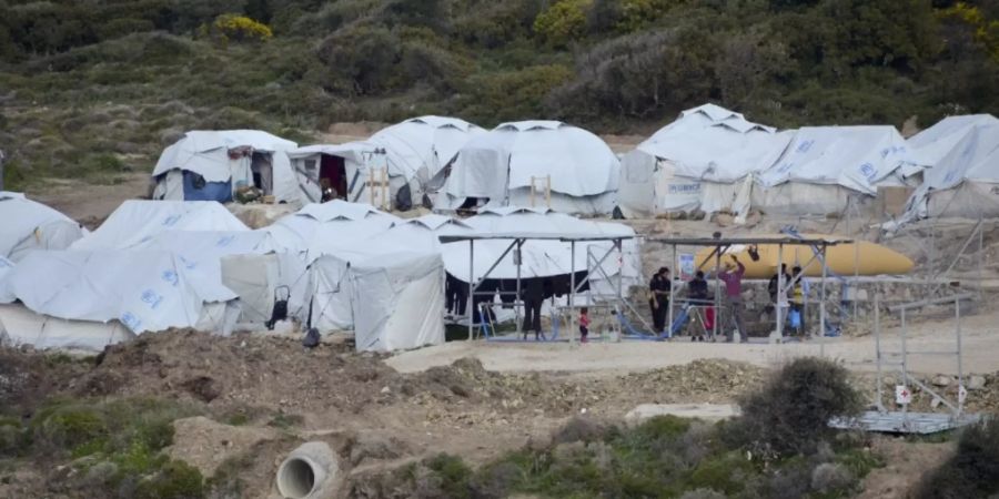 ARCHIV - Geflüchtete Menschen stehen im Flüchtlingslager Kara Tepe in der Nähe von Mytilini auf Lesbos vor Zelten. Foto: Panagiotis Balaskas/AP/dpa