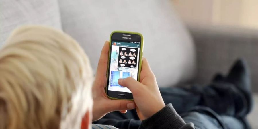 Ein Kind mit einem Smartphone. Wann ist der beste Zeitpunkt für das erste Gerät?. Foto: Tobias Hase/dpa