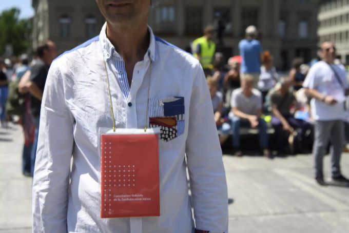 Ein Demonstrant trägt die Schweizerische Bundesverfassung, auf dem Bundesplatz, während einer Demonstration gegen Massnahmen des Bundes im Zusammenhang mit dem Coronavirus, am Samstag, 27. Juni 2020 in Bern. Coronavirus Demo