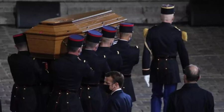 Der Sarg des ermordeten Lehrers Samuel Paty wird während der nationalen Gedenkveranstaltung in den Hof der Universität Sorbonne getragen. Foto: Francois Mori/AP/Pool/dpa