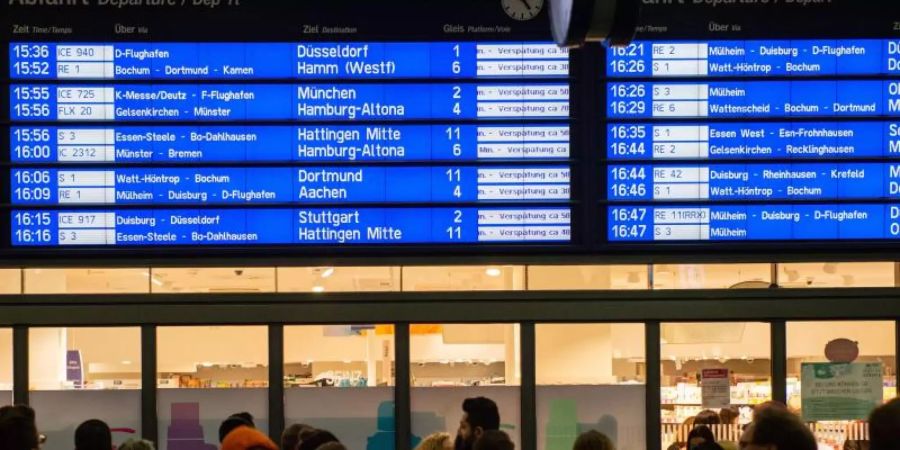 Menschen warten im Essener Hauptbahnhof vor der Anzeigetafel, auf der zahlreiche Zugverspätungen angegeben werden. Foto: Lisa Ducret/dpa