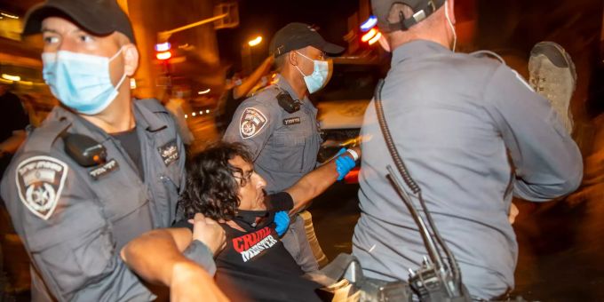 Polizisten tragen einen Demonstranten bei einem Protest gegen den Ministerpräsidenten Benjamin Netanjahu vor dessen Residenz in Jerusalem. benjamin netanjahu