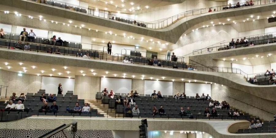 Besucher warten auf den Beginn des Konzertes "Come together" in der Elbphilharmonie. Foto: Axel Heimken/dpa