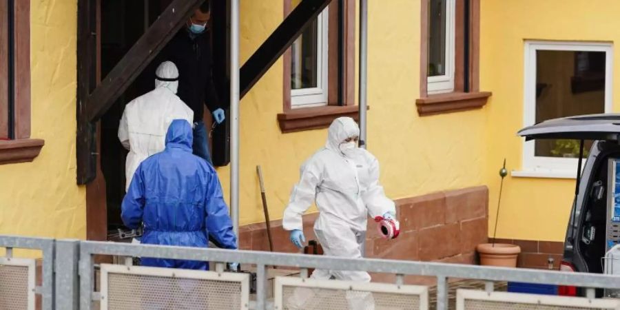 Mitarbeiter der Spurensicherung auf einem Anwesen in Weilerbach. Foto: Uwe Anspach/dpa