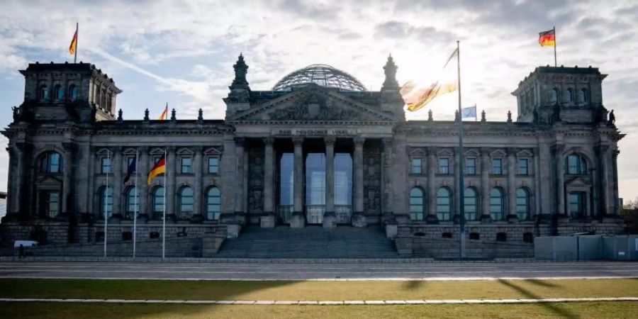 Die Sonne steht am Morgen hinter dem Reichstagsgebäude mit dem Bundestag. Foto: Kay Nietfeld/dpa