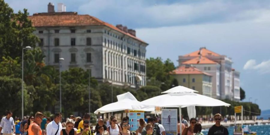 Touristen spazieren an der Uferpromenade in Zadar entlang. Ganz Kroatien gilt ab Samstag als Risikogebiet. Foto: Marko Dimic/Pixsell/Xinhua/dpa