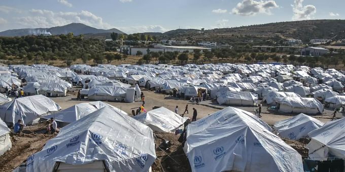 ARCHIV - Migranten gehen nach starken Regenfällen durch das Flüchtlingslager «Kara Tepe». Das provisorische Zeltlager «Kara Tepe» war in Windeseile errichtet worden, nachdem das ursprüngliche Lager Moria bei einem Grossbrand fast völlig zerstört worden war. Foto: Panagiotis Balaskas/AP/dpa ARCHIV - Migranten gehen nach starken Regenfällen durch das Flüchtlingslager «Kara Tepe». Das provisorische Zeltlager «Kara Tepe» war in Windeseile errichtet worden, nachdem das ursprüngliche Lager Moria bei einem Grossbrand fast völlig zerstört worden war. Foto: Panagiotis Balaskas/AP/dpa