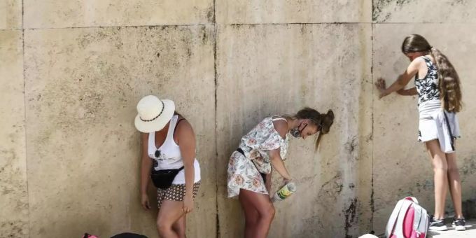 Touristinnen kühlen sich am Trevi-Brunnen in Rom ab. rom