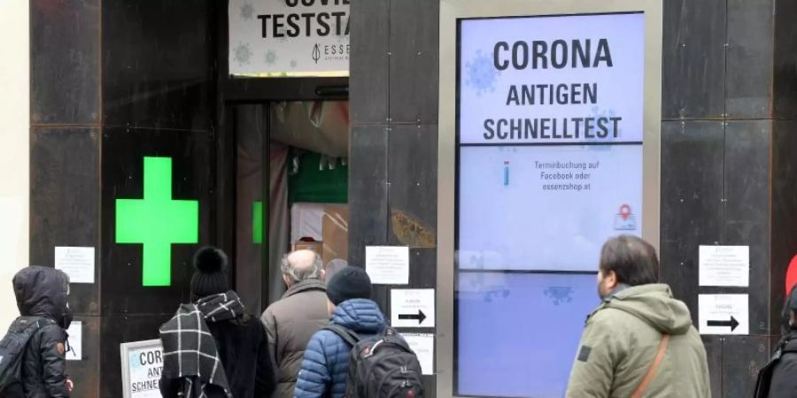 Menschen warten vor einer Apotheke in Wien auf einen Schnelltest. Die Sieben-Tage-Inzidenz liegt in Österreich bei rund 240. Foto: Roland Schlager/APA/dpa