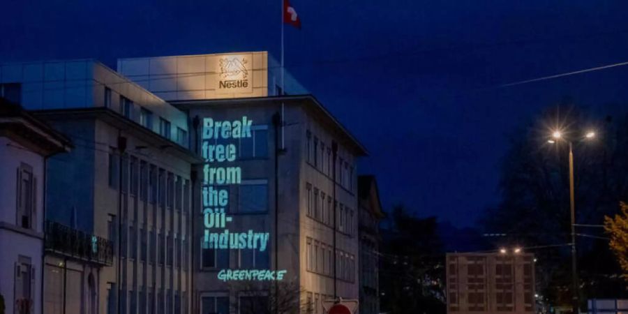 Die Umweltorganisation Greenpeace hat ihre Forderungen an die Fassade eines Nestlé-Betriebes in La-Tour-de-Peilz projeziert. (Bild: Greenpeace)