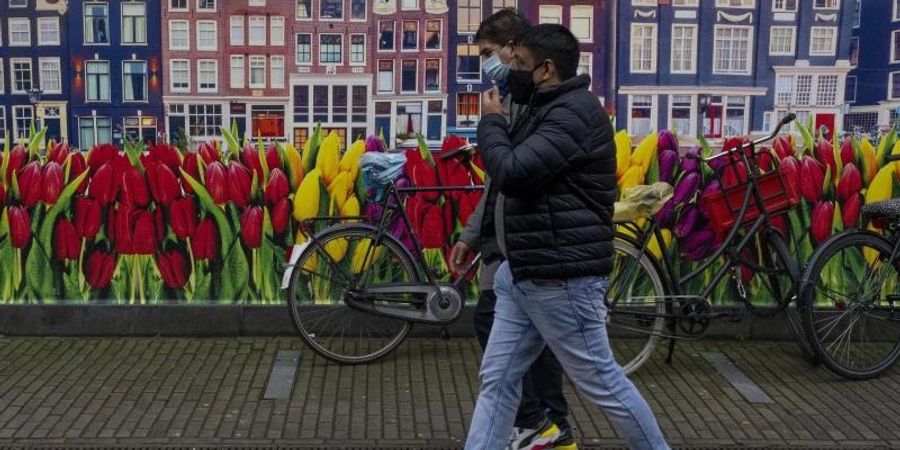 Passanten in Amsterdam. Foto: Peter Dejong/AP/dpa