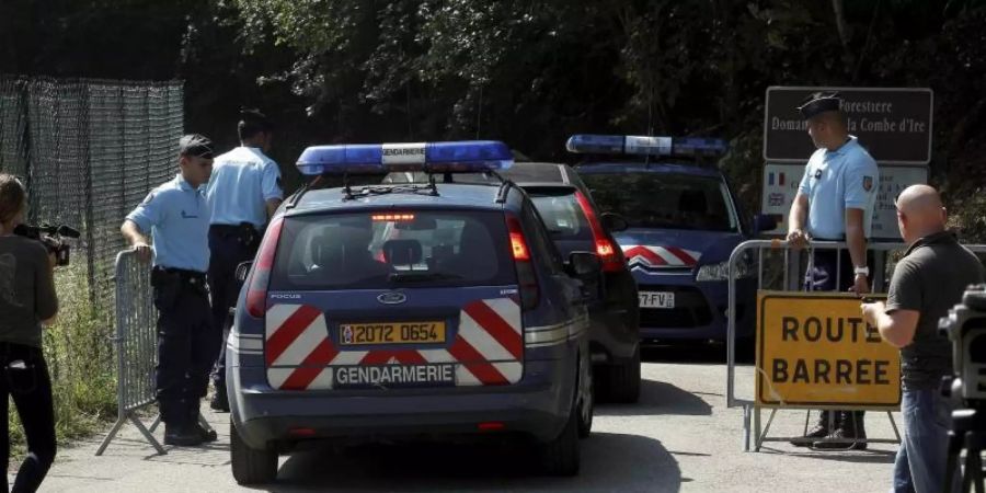 Die Polizei sperrt die Strasse zum Tatort ab (2012). Foto: Norbert Falco/Le Dauphine/MAXPPP/dpa