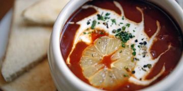 Suppe rot Orangenscheibe Schmand Toastbrot