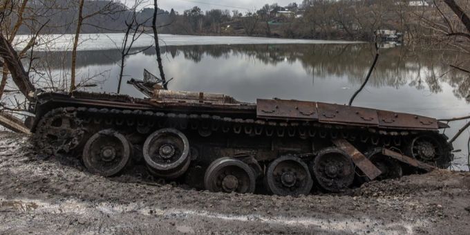 Ein russischer Panzer liegt beschädigt an einem See. russland