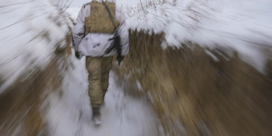 dpatopbilder - Ein ukrainischer Soldat geht an der Frontlinie im Osten des Landes durch einen Graben. Foto: Vadim Ghirda/AP/dpa