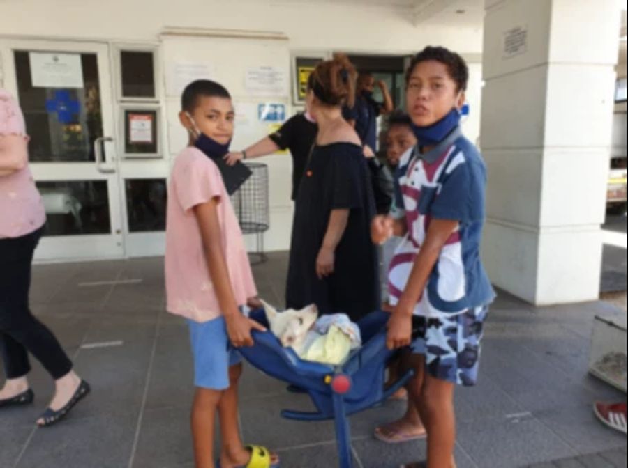 Die drei Kinder kommen mit Bruno im Kindersitz beim Tierheim an.