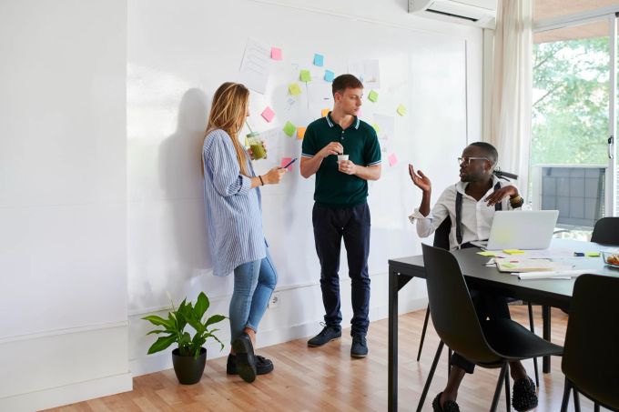 Wer als junger Mensch ein Unternehmen gründen möchte, braucht nicht nur gute Ideen, sondern auch Business-Wissen. Büro Meeting Frau Männer Post-its Tisch