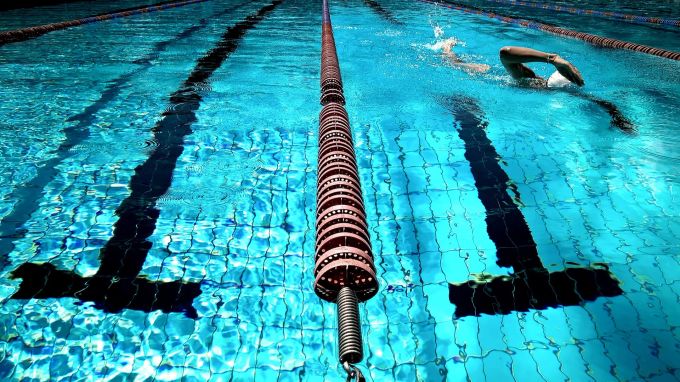 Schwarze Striche auf dem Boden markieren die Bahnen im Schwimmbad. Schwimbad Bahnen Abtrennung Schwimmer