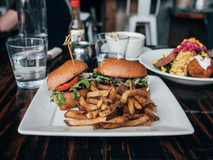 Viele Restaurants führen auch vegane Burger auf der Speisekarte. Vegan Burger mit Pommes