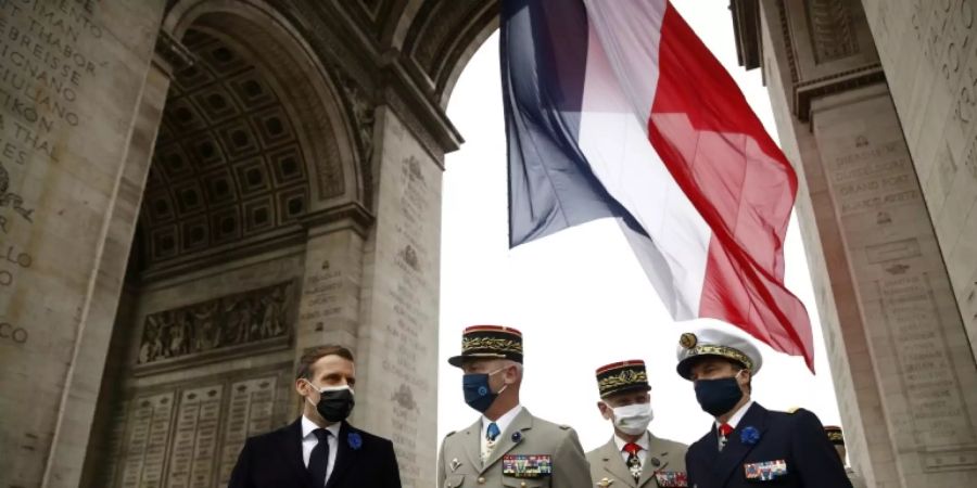 Präsident Macron mit Armeevertretern am Triumphbogen