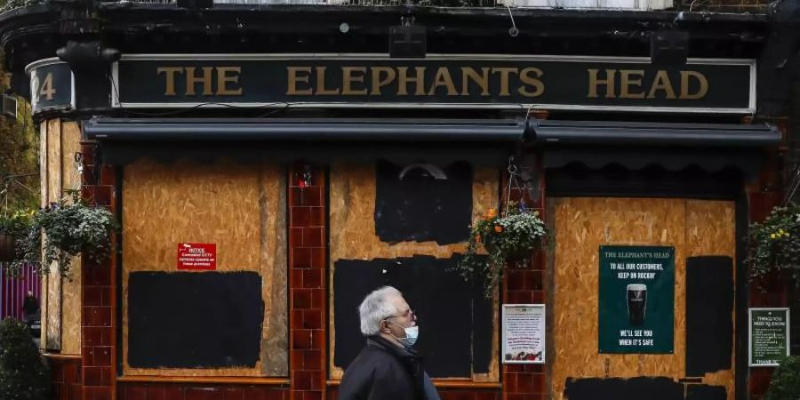 Ein Mann geht an einem geschlossenen Pub in London vorbei. Foto: Han Yan/XinHua/dpa