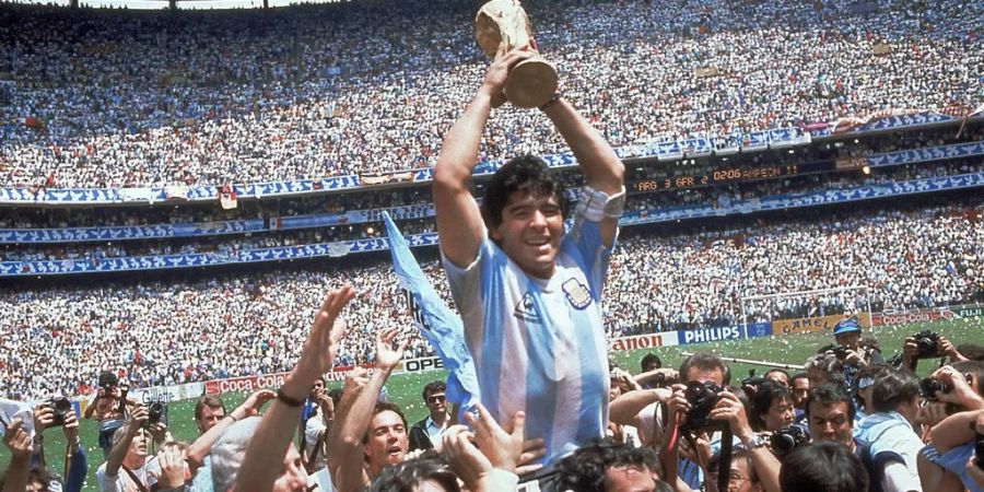 Argentiniens Fussball-Gott Diego Maradona (†60) stemmt 1986 den WM-Pokal.