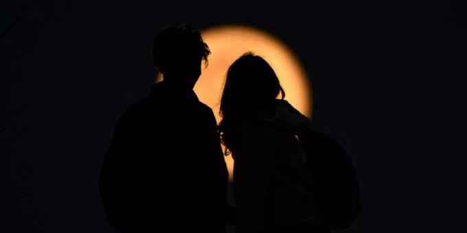 Zwei Menschen vor dem Mond. (Symbolbild) nacht