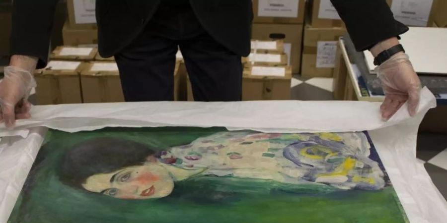 Ein Mitarbeiter der Galerie Ricci Oddi packt das wiederentdeckte Klimt-Gemälde "Bildnis einer Frau" aus. Foto: -/Galerie Ricci Oddi /dpa