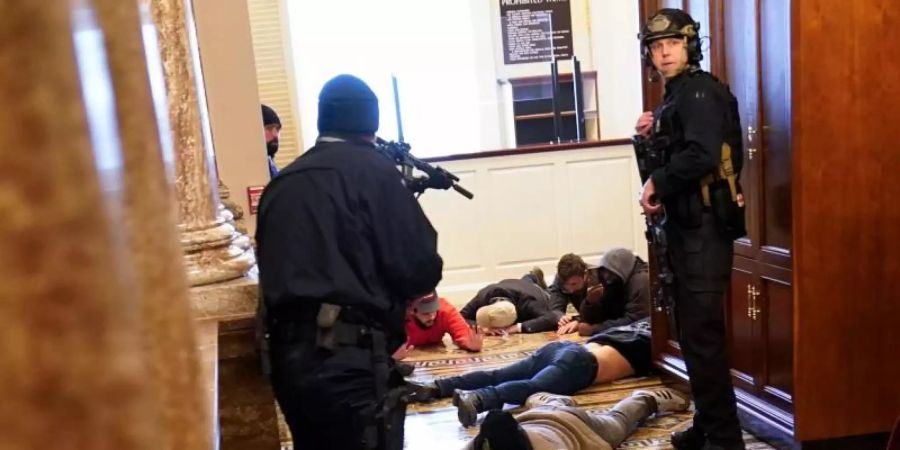 Demonstranten werden in der Nähe der Repräsentantenhaus-Kammer festgehalten. Foto: Andrew Harnik/AP/dpa