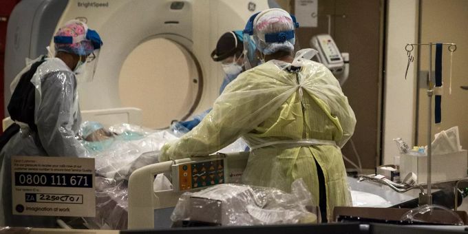 Medizinisches Personal in Schutzkleidung bereitet eine mit dem Coronavirus infizierte Person für eine CT-Untersuchung vor. Coronavirus - Südafrika