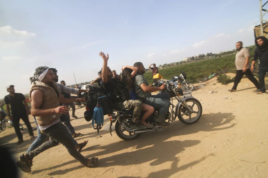 Hamas-Kämpfer entführen eine Zivilistin auf dem Motorrad.