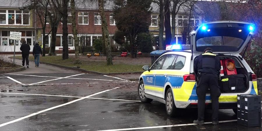 Ein Polizeiauto steht vor dem Gebäude einer  Grund- und Hauptschule in Lüdingworth. Dort hat ein Mädchen ein anderes mit einem Messer schwer verletzt.