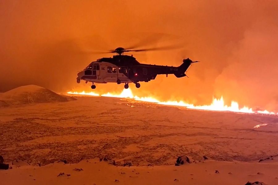 Ein Hubschrauber wagt sich in die Nähe vom Magma. Uncredited/Icelandic Coast Guard/AP/dpa