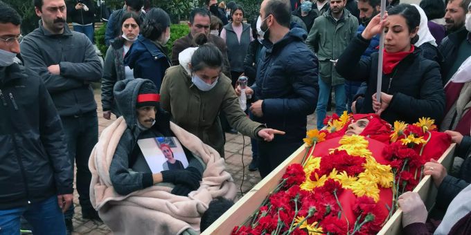 Trauergäste nehmen Abschied am offenen Sarg von Helin Bölek, Mitglied der prominenten türkischen Folk-Band Grup Yorum. Im Rollstuhl beim Sarg sitzt der abgemagerte Ibrahim Gökcek. Hungerstreik
