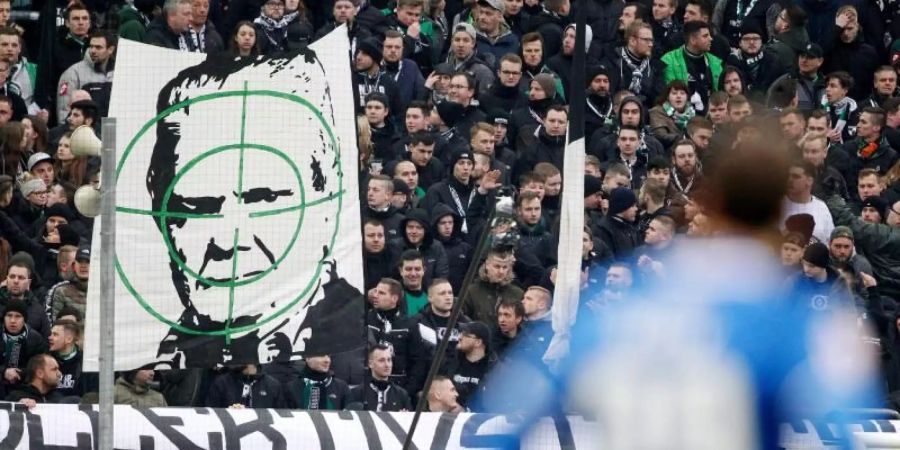 Gladbacher Fans zeigen ein Transparent mit dem Konterfei von Hoffenheim-Mäzen Dietmar Hopp. Foto: Roland Weihrauch/dpa